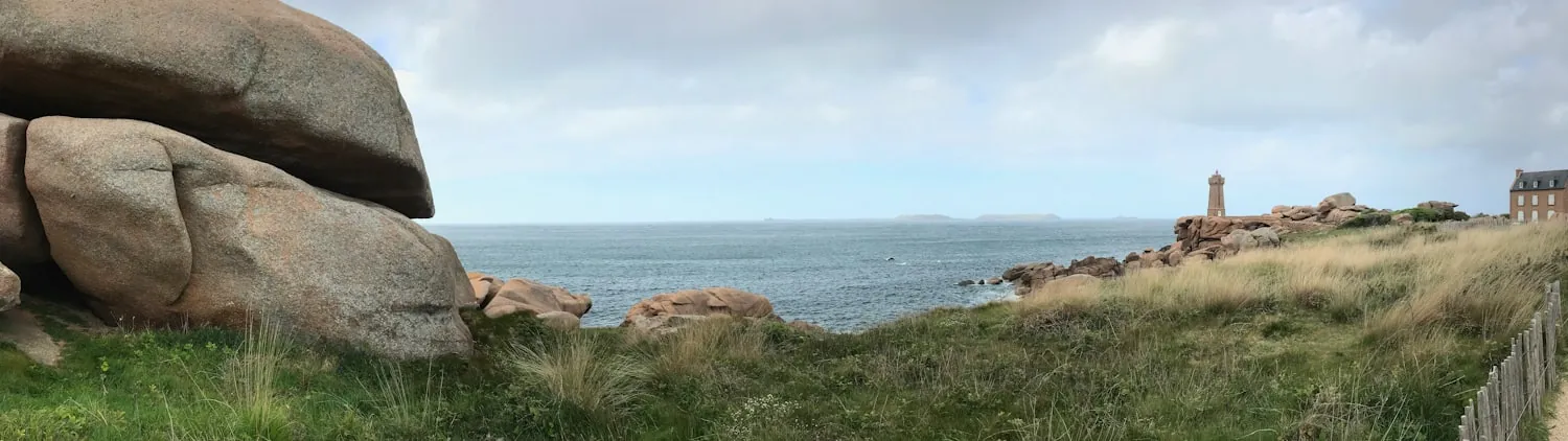 Côte de granit rose au crépuscule, phare au loin